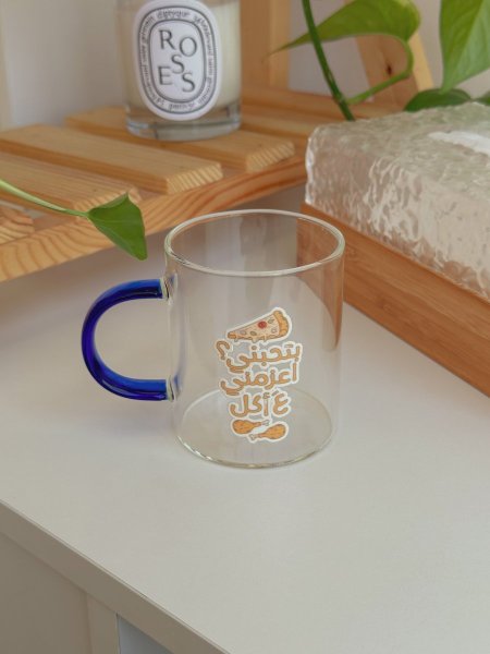 كوب بعبارة "بتحبني أعزمني على أكل"