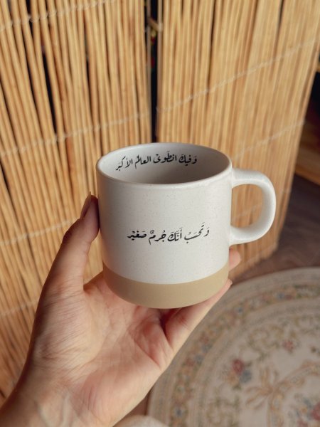 كوب بعبارة "وتحسب أنك جرم صغير وفيك انطوى العالم الأكبر"