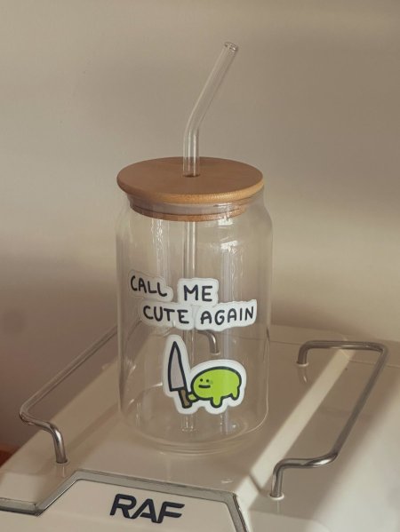 كوب شفاف مع غطى وشلمونة بعبارة "call me cute again”