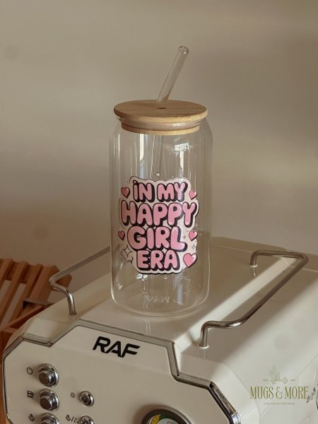 كوب شفاف مع غطى وشلمونة بعبارة "in my happy girl era”