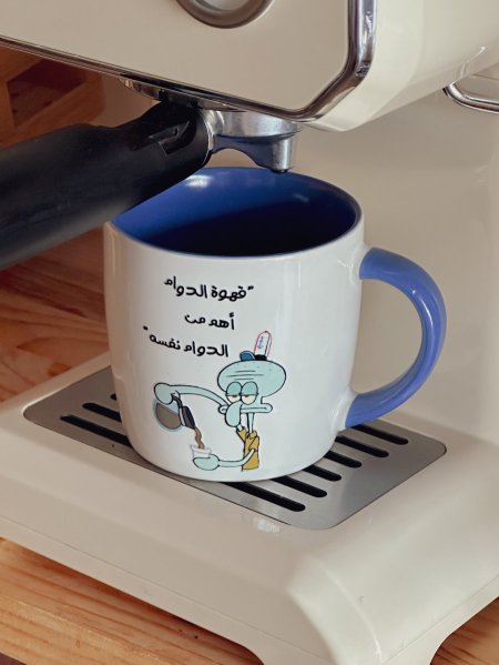 "كوب بعبارة "قهوة الدوام أهم من الدوام نفسه"