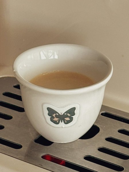 فنجان قهوة سادة مع رسمة فراشات