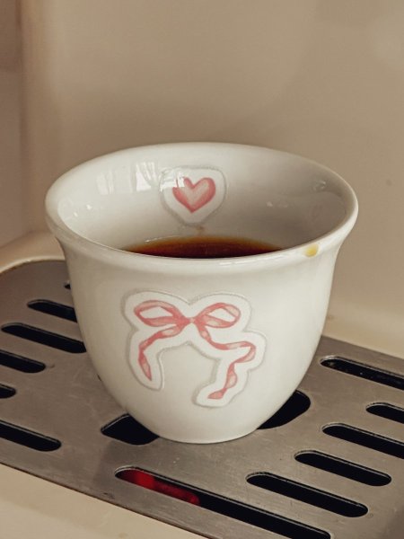 فنجان قهوة سادة ابيض برسمة فيونكة مع اضافة من الداخل